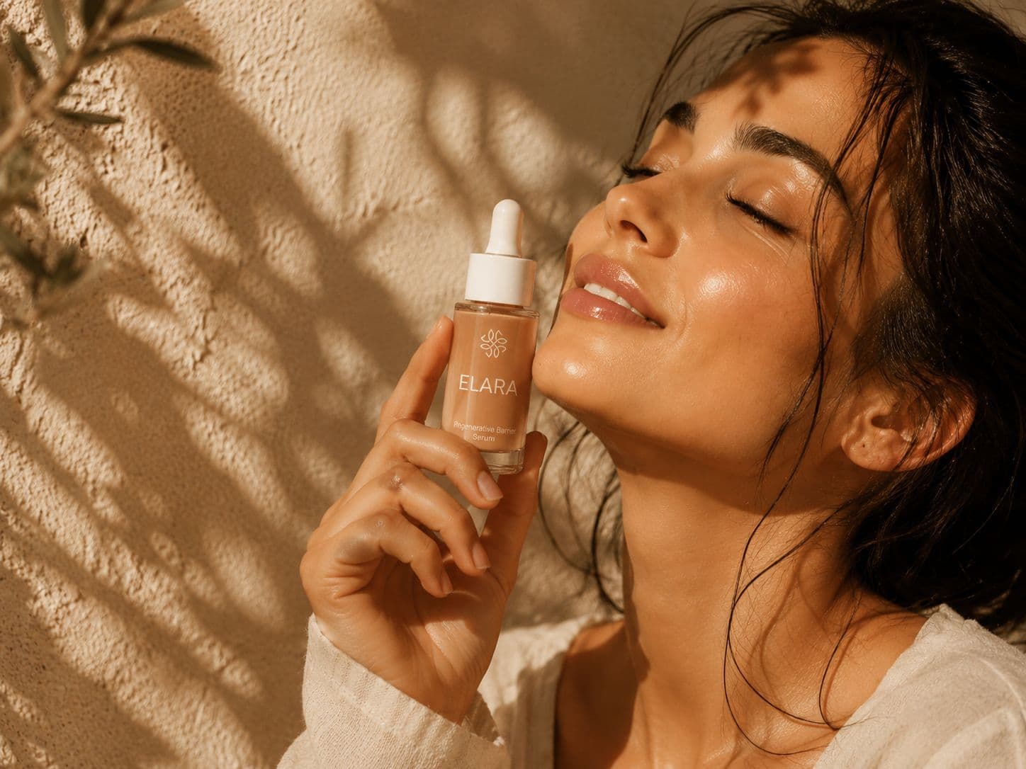 Woman with glowing skin holding ELARA bottle under soft olive tree shadows